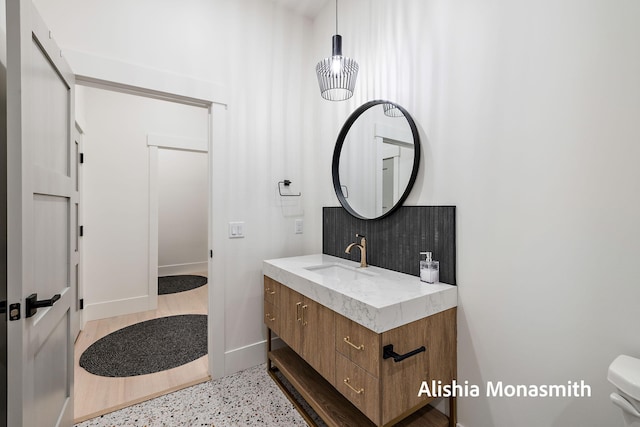 300 Washington Ave Unit 1, Grand Haven, MI 49417 - bathroom featuring vanity, tasteful backsplash, and speckled floor