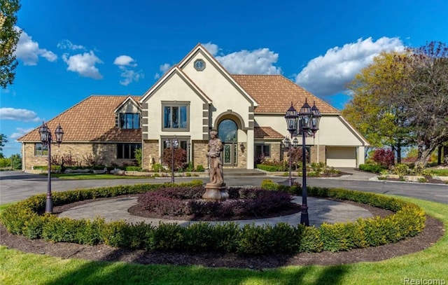 view of front of home featuring stone siding, stucco siding, and a tiled roof