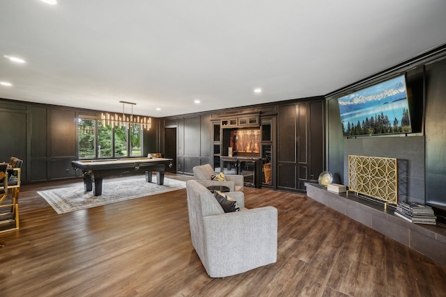 living area with dark wood-style floors, a decorative wall, pool table, and a high end fireplace