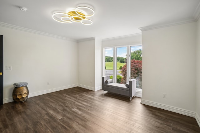 empty room featuring a chandelier, baseboards, wood finished floors, and ornamental molding