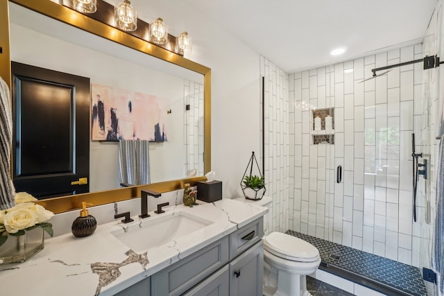 bathroom featuring a shower stall, toilet, and vanity