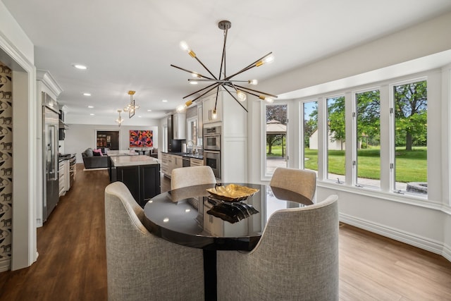 dining room with recessed lighting, baseboards, dark wood-type flooring, and a notable chandelier