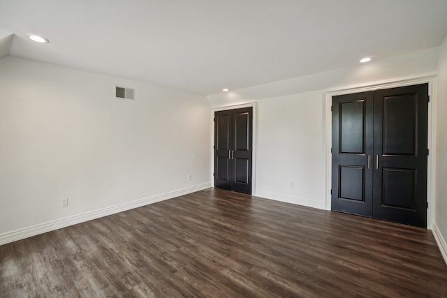 empty room featuring dark wood finished floors, recessed lighting, baseboards, and visible vents