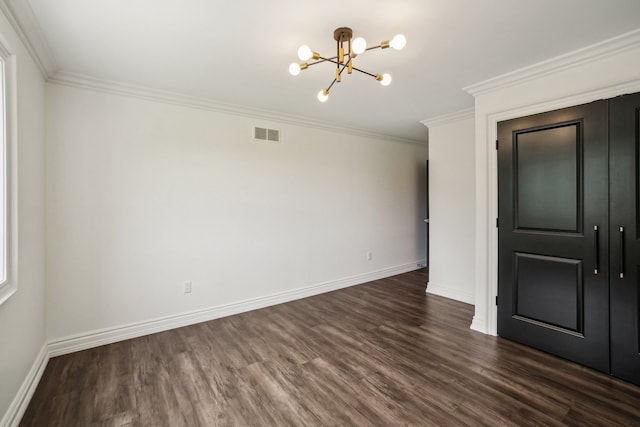 empty room with visible vents, dark wood finished floors, crown molding, baseboards, and a chandelier