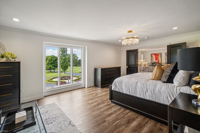 bedroom featuring an inviting chandelier, crown molding, recessed lighting, and wood finished floors