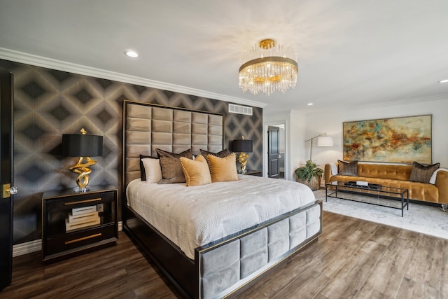 bedroom with visible vents, wood finished floors, ornamental molding, and a chandelier