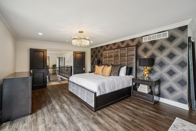 bedroom featuring a chandelier, visible vents, baseboards, and wood finished floors