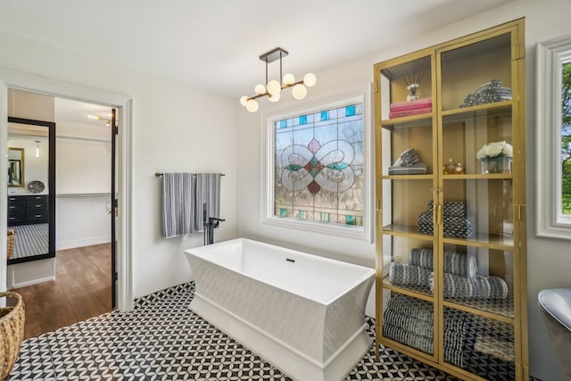 bathroom featuring a freestanding tub and an inviting chandelier