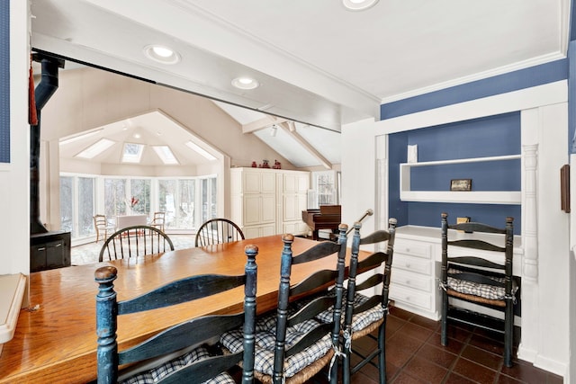 dining area featuring dark tile patterned floors, recessed lighting, vaulted ceiling with skylight, and crown molding