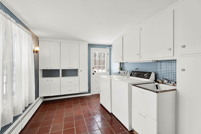 laundry room with a baseboard heating unit, cabinet space, separate washer and dryer, and dark tile patterned floors