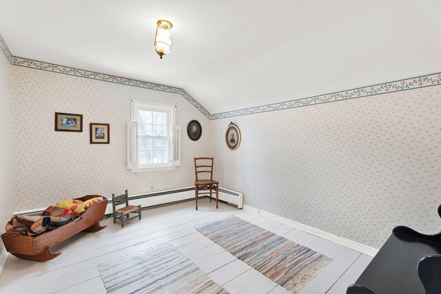 sitting room with wallpapered walls, lofted ceiling, baseboards, and hardwood / wood-style floors