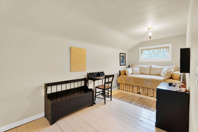 living area with light wood-type flooring, baseboards, and lofted ceiling