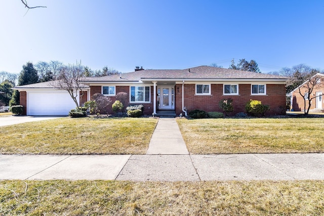 ranch-style home with brick siding, an attached garage, concrete driveway, and a front lawn