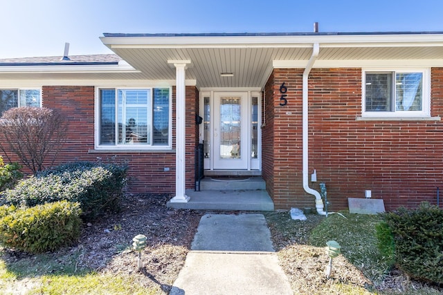 view of exterior entry with brick siding