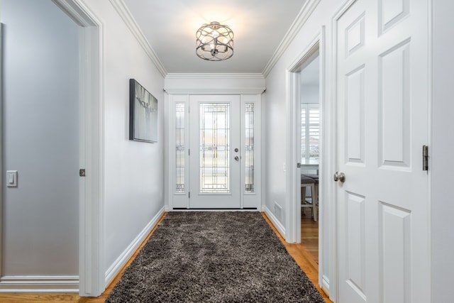 foyer with visible vents, baseboards, light wood-style flooring, and crown molding