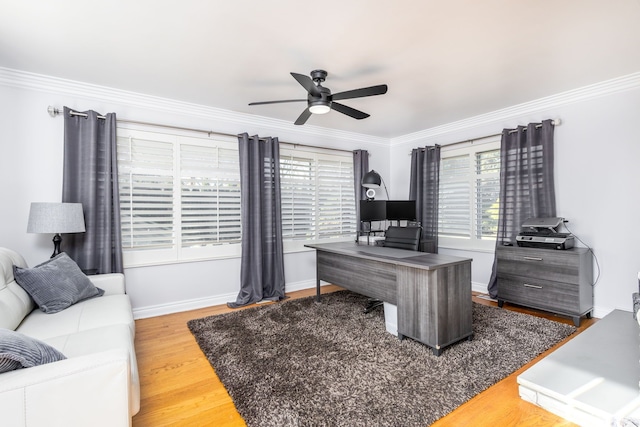 office area featuring baseboards, crown molding, a ceiling fan, and wood finished floors