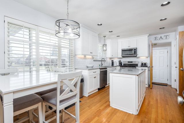 kitchen with a sink, white cabinetry, a wealth of natural light, and stainless steel appliances