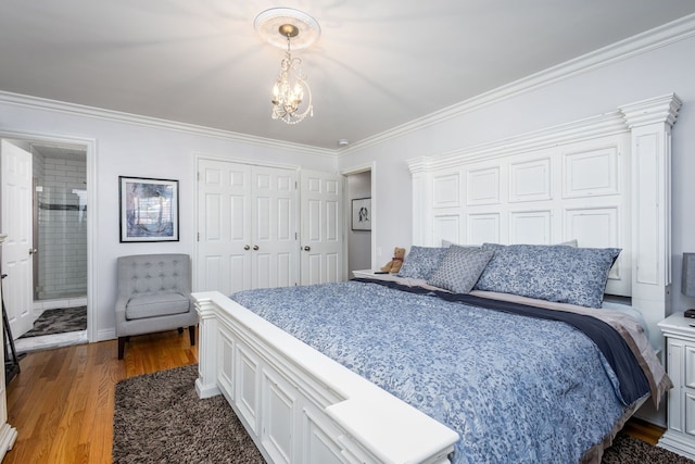 bedroom featuring two closets, crown molding, and wood finished floors