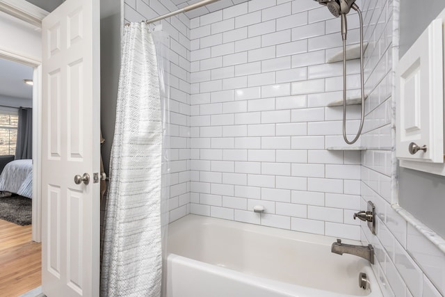 ensuite bathroom featuring wood finished floors, ensuite bath, and shower / bath combo