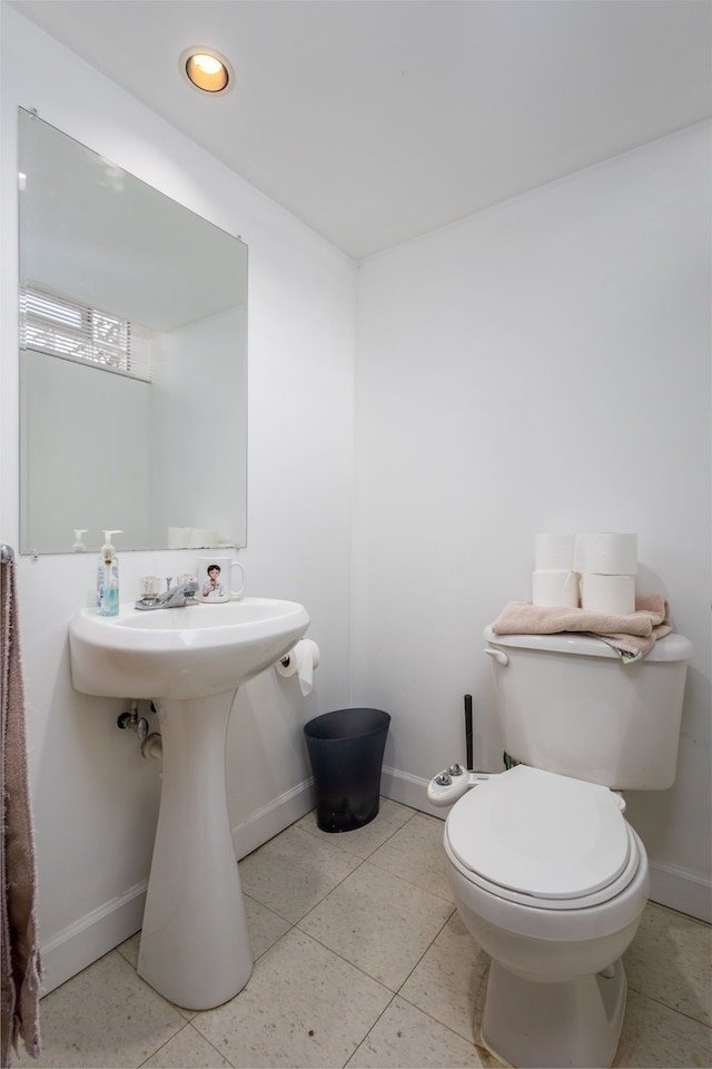 bathroom featuring baseboards, toilet, and tile patterned flooring