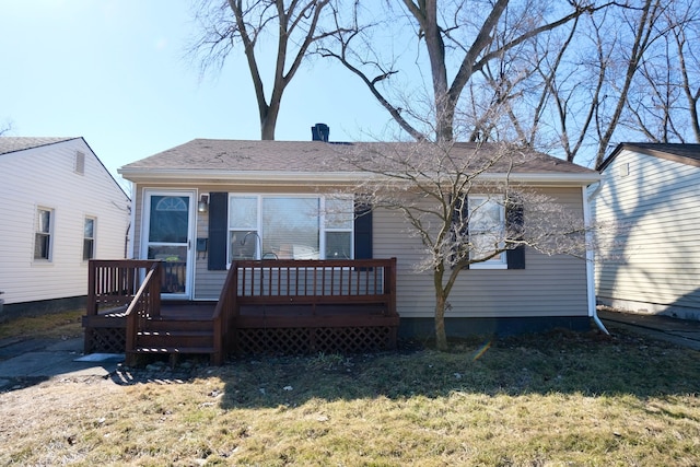 back of property featuring a wooden deck and a yard