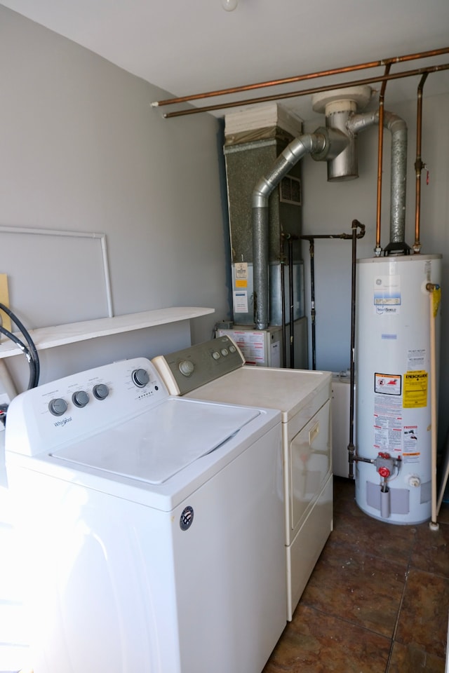 washroom with water heater, laundry area, and washing machine and dryer