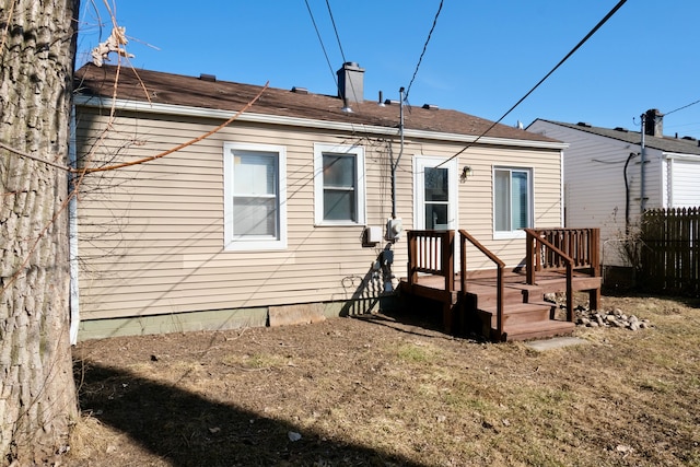 back of house featuring fence and a chimney