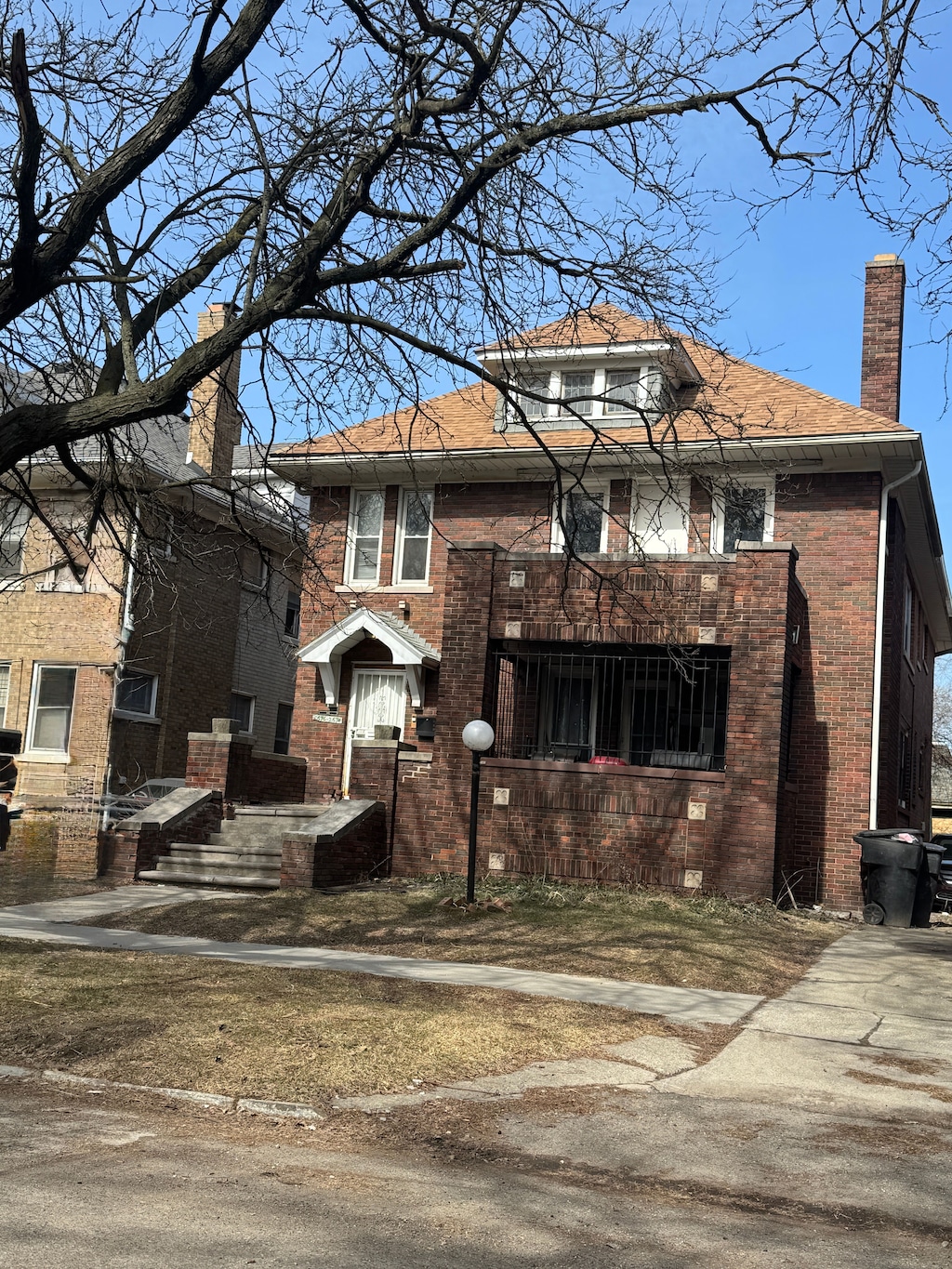 american foursquare style home with brick siding and a chimney