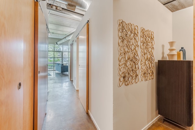 hall with baseboards, concrete flooring, and expansive windows