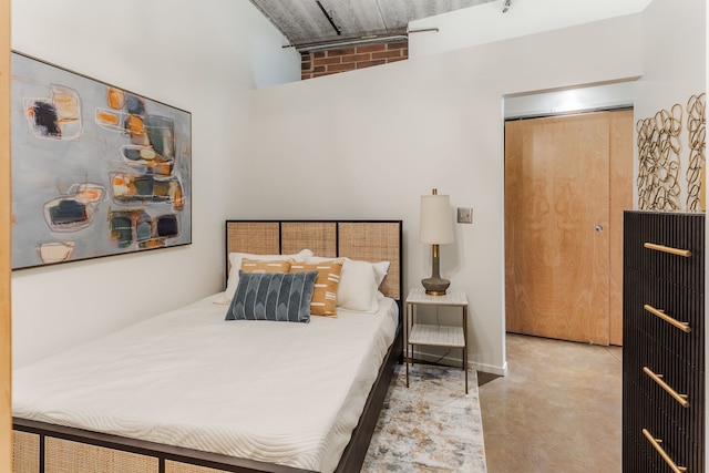 bedroom with finished concrete floors and a towering ceiling