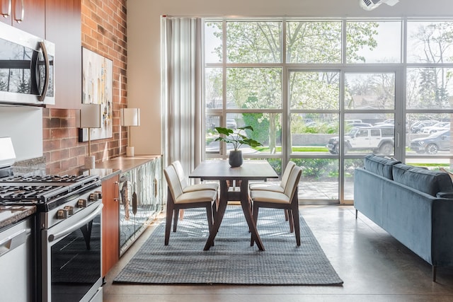 dining room featuring concrete floors and brick wall