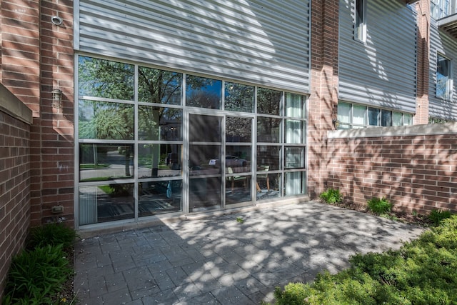 doorway to property with brick siding