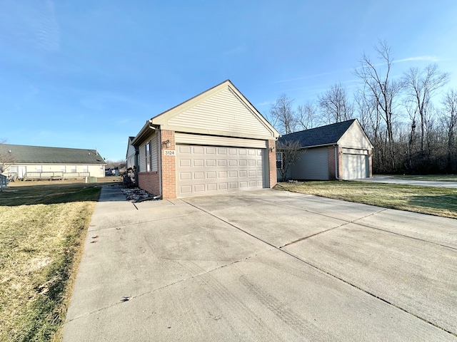 view of property exterior featuring a detached garage, a yard, brick siding, and an outdoor structure