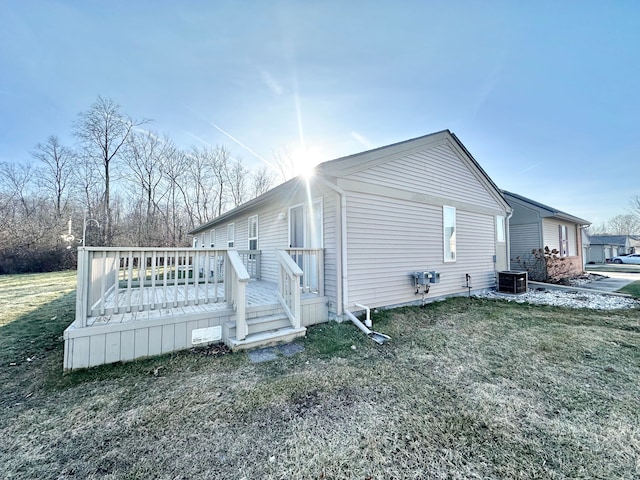 view of property exterior with central air condition unit, a yard, and a deck