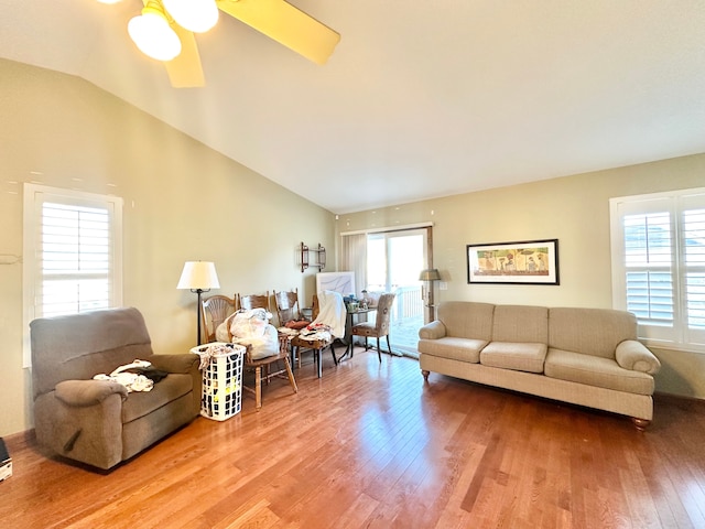 living area with a ceiling fan, vaulted ceiling, plenty of natural light, and wood finished floors