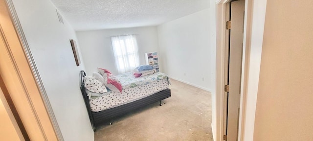 bedroom with baseboards and a textured ceiling