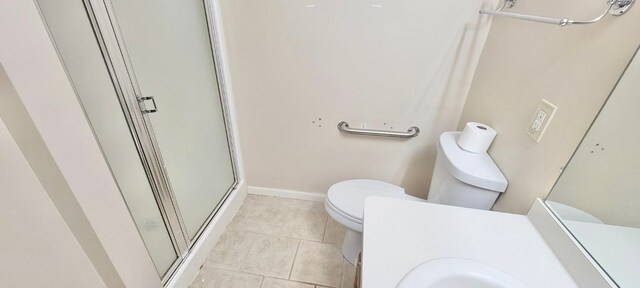 bathroom with tile patterned floors, toilet, a stall shower, baseboards, and vanity