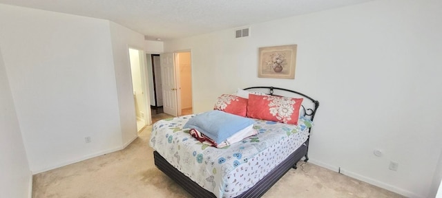 carpeted bedroom with visible vents and baseboards