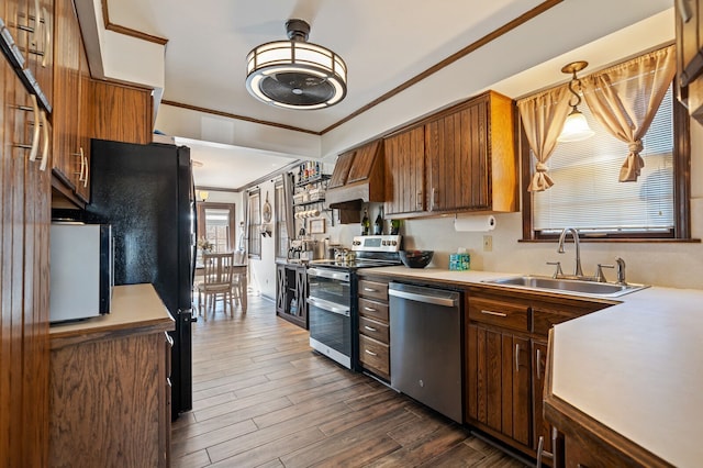 kitchen featuring stainless steel appliances, dark wood-type flooring, light countertops, and a sink