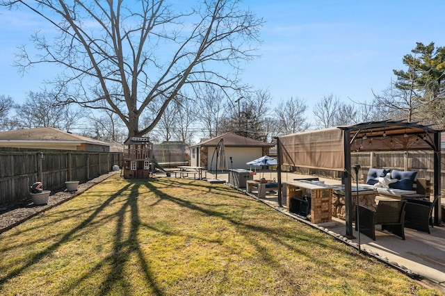 view of yard with an outbuilding, a patio, fence, a playground, and an outdoor hangout area