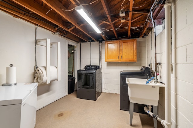 laundry area with a sink, cabinet space, and separate washer and dryer