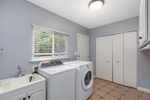 washroom featuring washer and dryer, cabinet space, and a sink