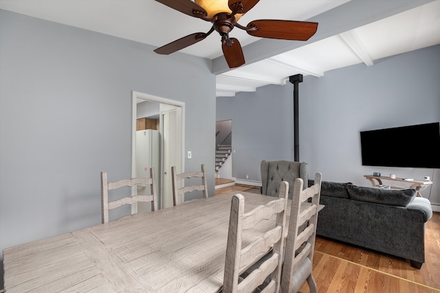 dining room featuring beam ceiling, a baseboard heating unit, wood finished floors, stairway, and ceiling fan