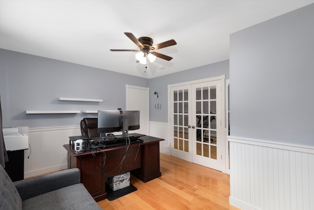 home office with light wood-style flooring, french doors, a wainscoted wall, and ceiling fan