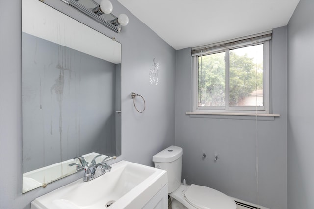 bathroom featuring toilet, baseboard heating, and vanity