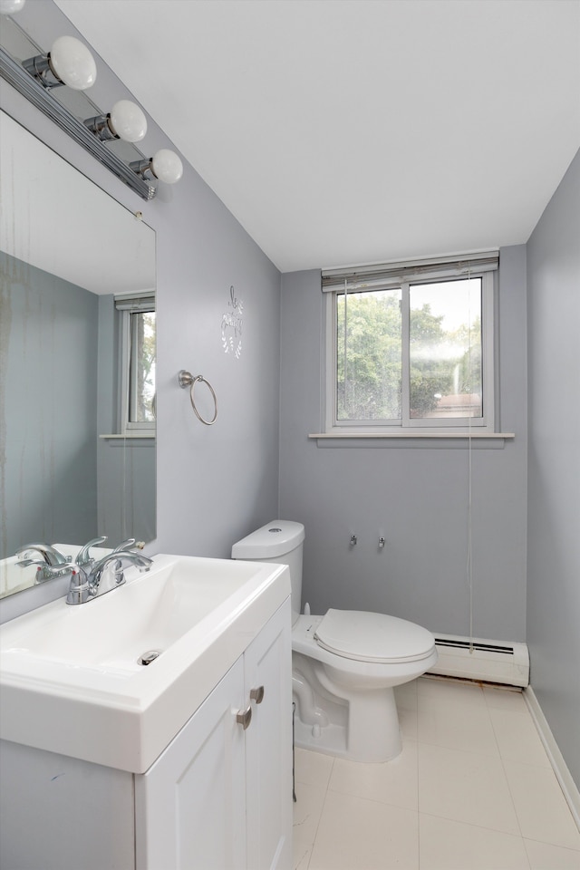 bathroom with a wealth of natural light, baseboard heating, toilet, and vanity