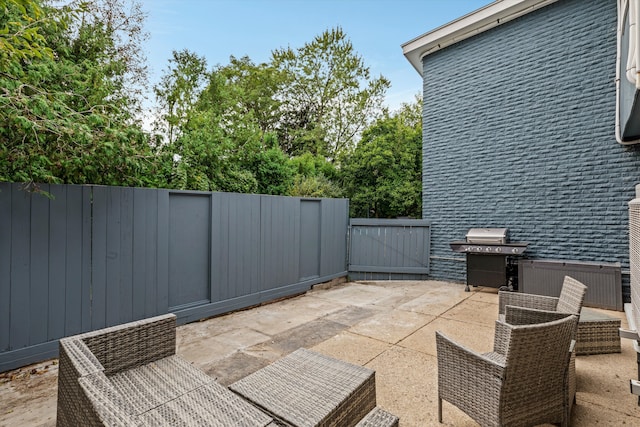 view of patio with area for grilling and fence