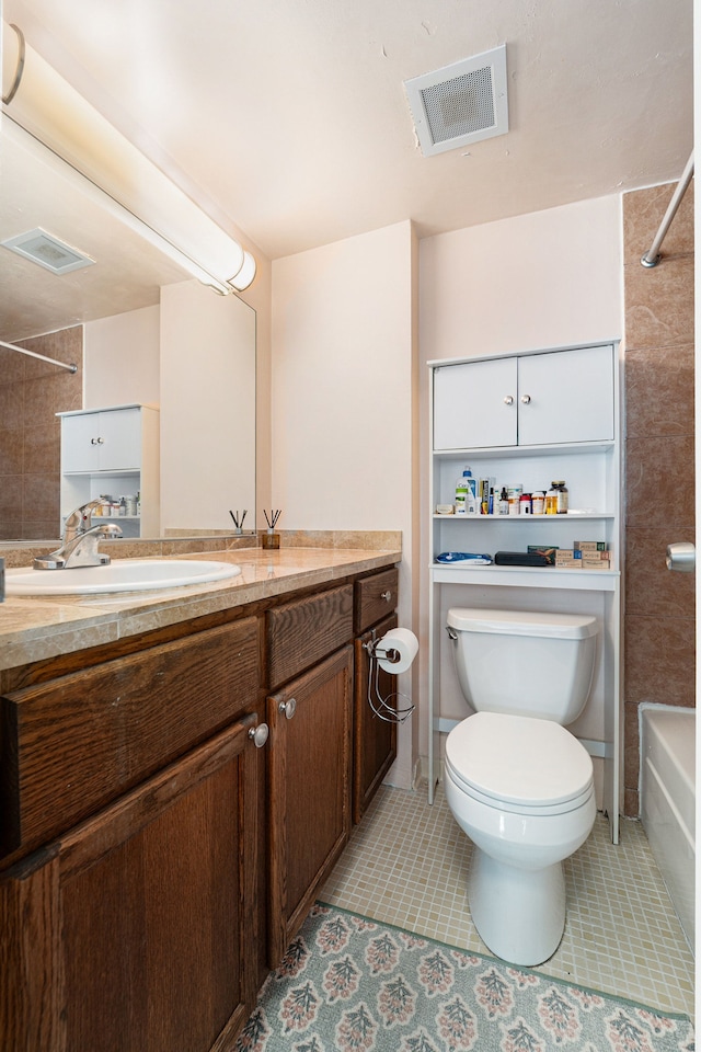 full bath with visible vents, toilet, vanity, and tile patterned flooring