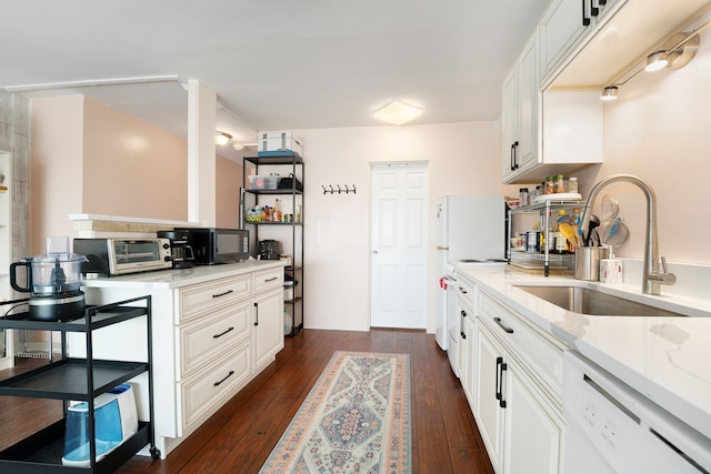 kitchen featuring dark wood finished floors, a toaster, range with electric stovetop, white dishwasher, and a sink