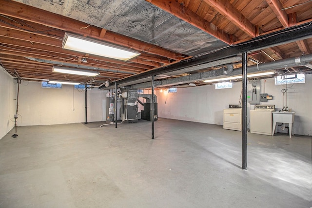 basement with gas water heater, separate washer and dryer, and a sink